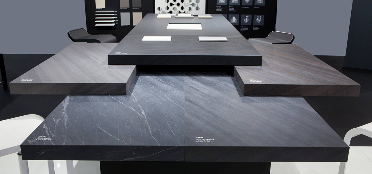 Moderne design tafel met verschillende zwarte HPL-panelen in steenlook, gepresenteerd op een interieurbeurs.