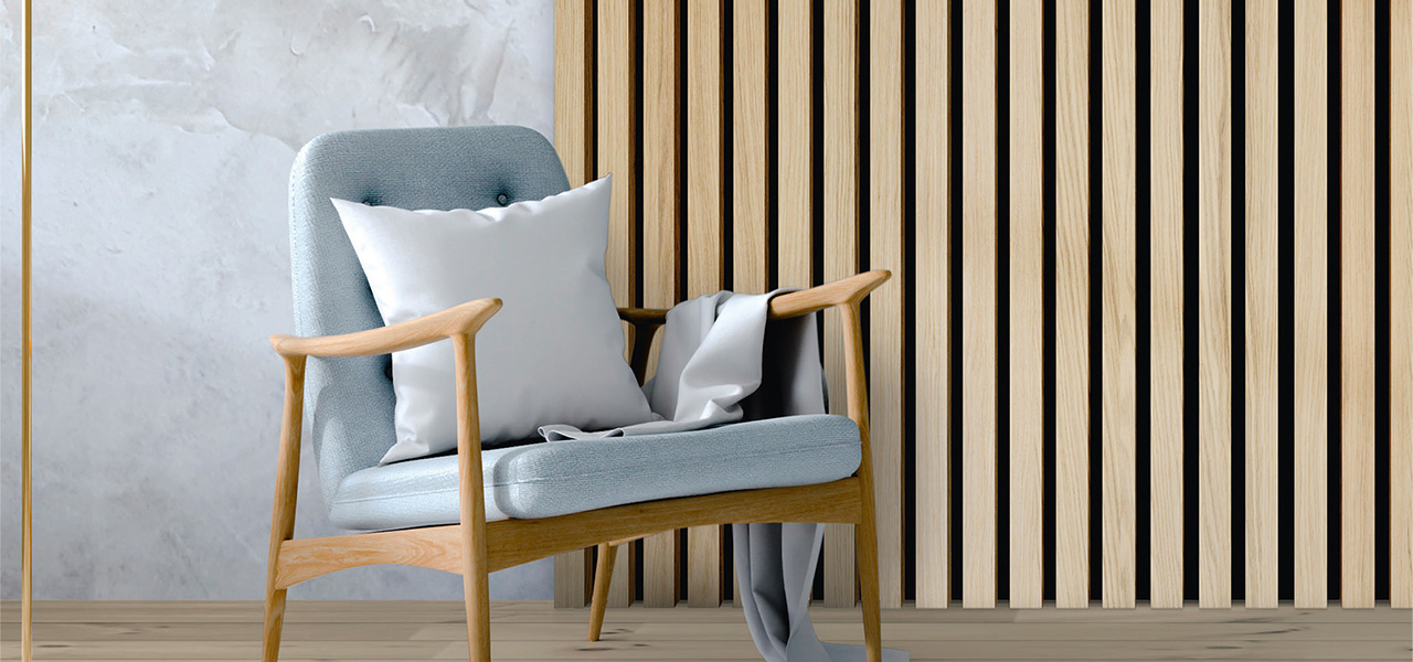 Een moderne stoel met houten poten en een lichtblauwe stoffen bekleding, voorzien van een wit kussen en een grijze deken, tegen een achtergrond van houten verticale latten en een muur met een subtiele marmerlook.