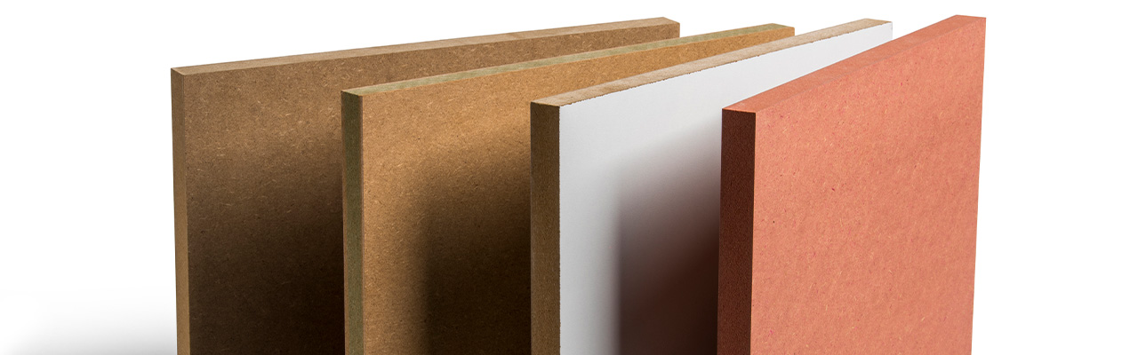  Vier MDF platen staan naast elkaar in verschillende uitvoeringen, variërend van onbewerkt bruin MDF, wit gelamineerd MDF tot een gekleurde rode MDF plaat.