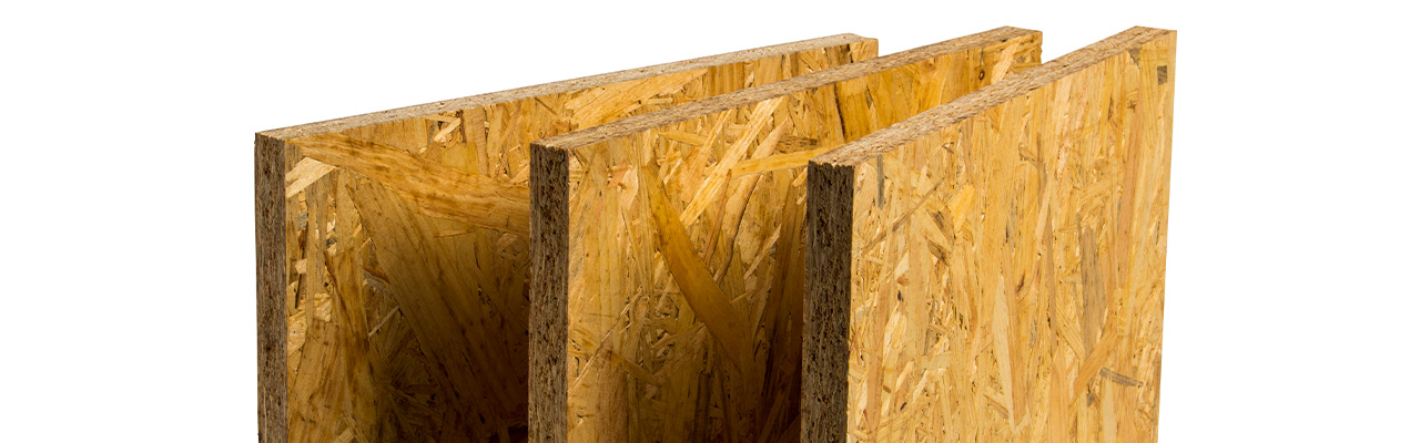 Drie OSB-platen staan rechtop naast elkaar, met de kenmerkende zichtbare houtvezels en spaanders.