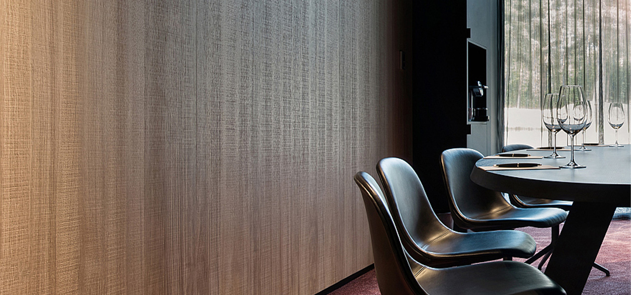 Decospan houten wandbekleding met elegante textuur in een moderne vergaderruimte met zwarte stoelen en een tafel.