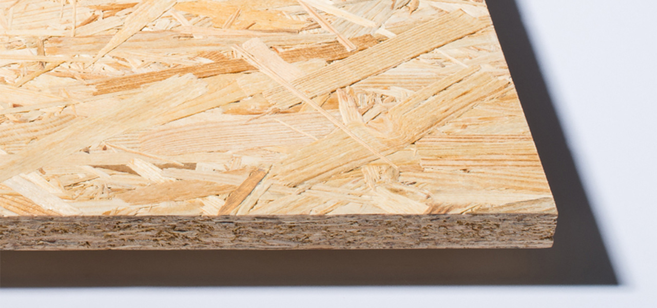 Een close-up van een OSB-plaat, waarbij de geperste houtspaanders en gelaagde structuur goed zichtbaar zijn.