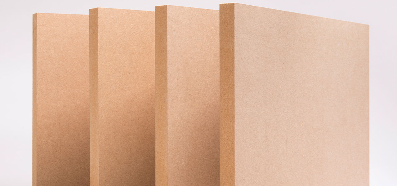 Vier onbehandelde MDF-platen van verschillende diktes, rechtop geplaatst met een glad en gelijkmatig oppervlak.