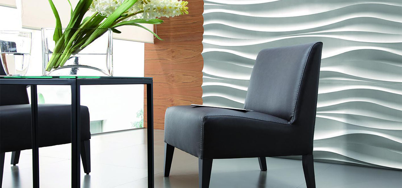 Een minimalistische ruimte met een zwarte stoel en een witte, golvende 3D-muur die zorgt voor een subtiel, elegant accent.