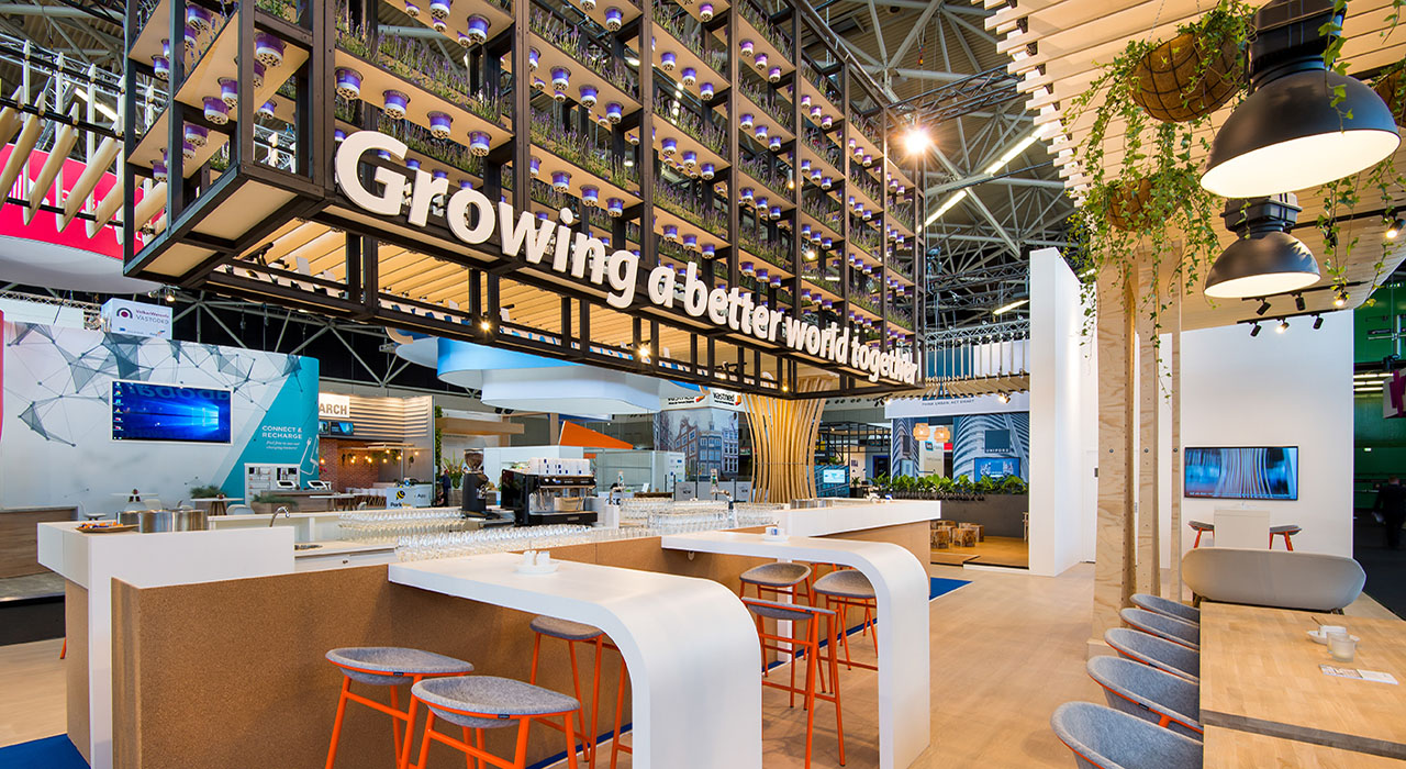 Rabobank stand PROVADA Beurs 2 – Open beursstand met houten constructies, veel groen en zithoeken.