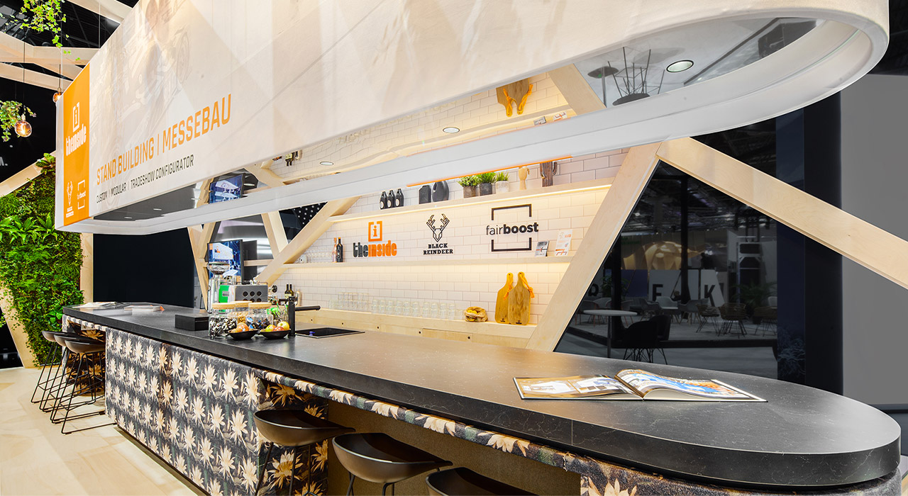 The Inside stand Euroshop Düsseldorf Duitsland 2 – Stijlvolle beursbar met zwart werkblad, houten accenten en decoratieve tegels.