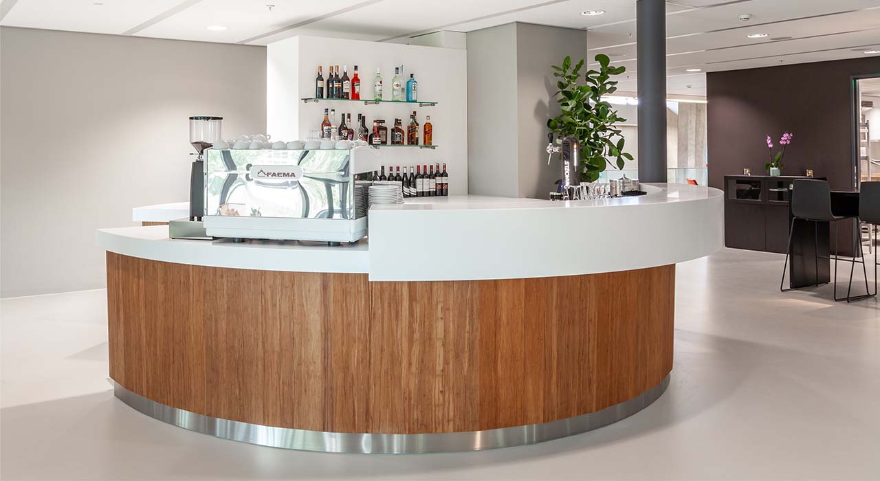 Moderne bar in de Technische Universiteit Eindhoven met houten panelen en witte bovenkant.