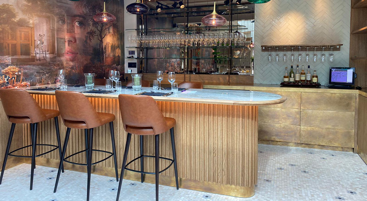 Bowling & Bistro Merlijn Oosterhout: Stijlvolle bar met leren barkrukken en glazen wijnrek.