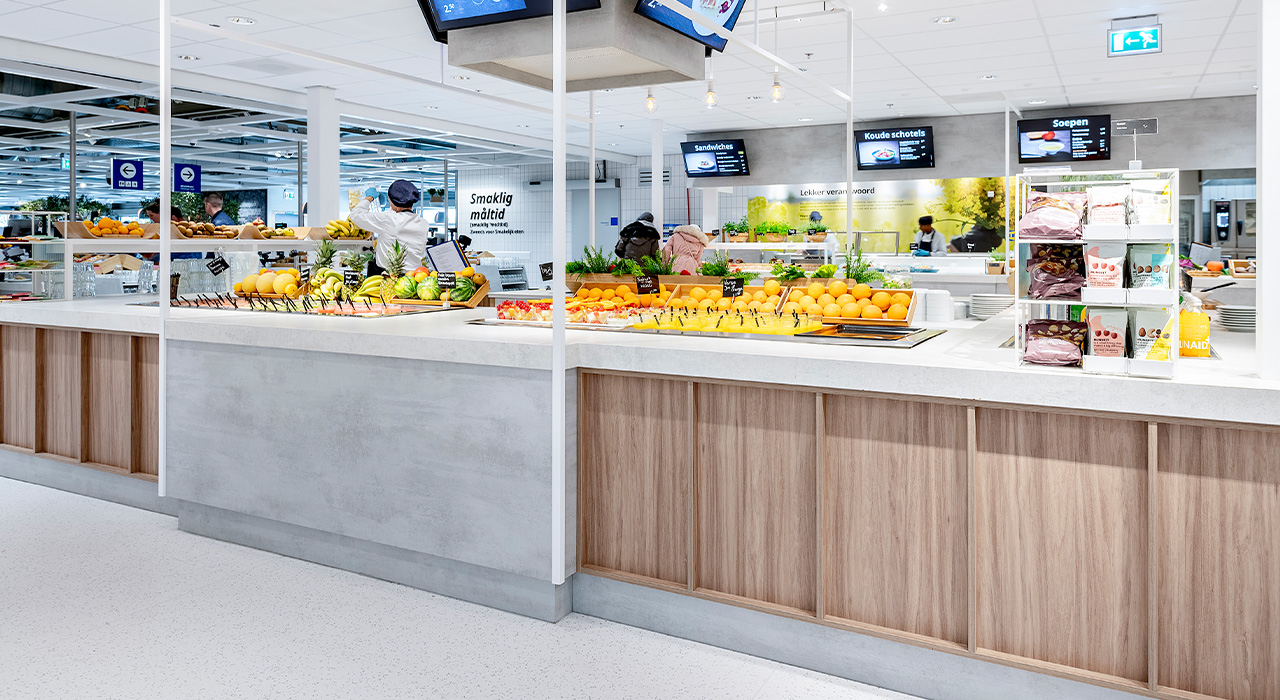 Buffet met fruit en snacks, in een Scandinavisch interieur met lichte kleuren en een open keuken op de achtergrond.